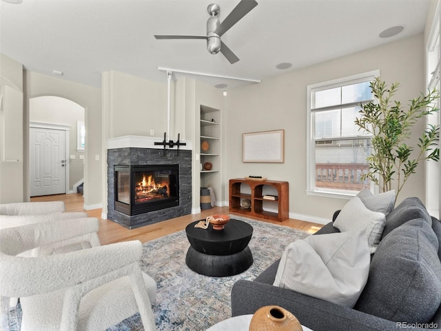 2821 Fulton St, Denver, CO 80238 - living area featuring ceiling fan, arched walkways, a multi sided fireplace, and light wood-style floors