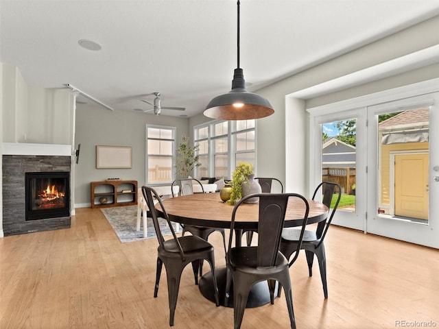 2821 Fulton St, Denver, CO 80238 - dining space featuring a glass covered fireplace, light wood finished floors, and a ceiling fan