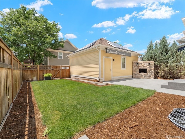 2821 Fulton St, Denver, CO 80238 - back of house featuring a patio area, solar panels, a fenced backyard, an outdoor stone fireplace, and a gate