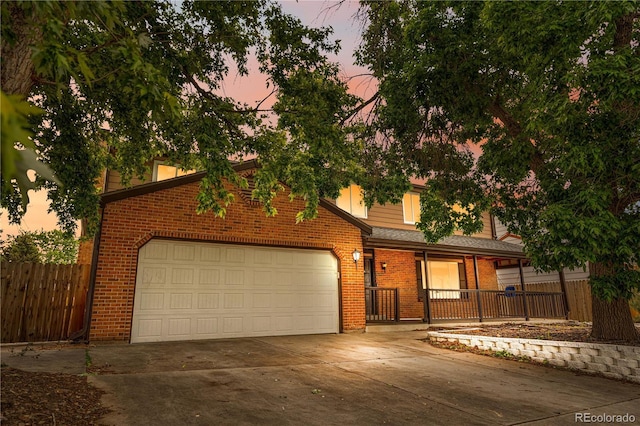 1758 S Tucson St, Aurora, CO 80012 - view of front of home featuring brick siding, driveway, a garage, and a porch