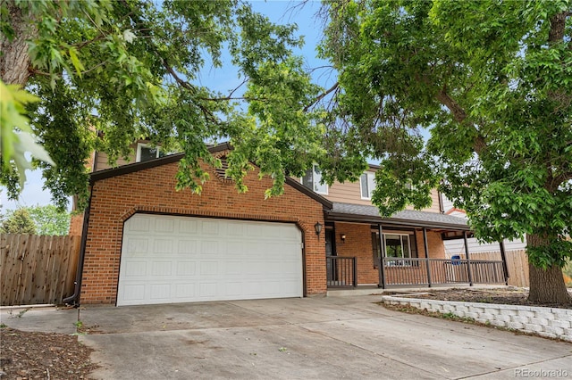1758 S Tucson St, Aurora, CO 80012 - view of front facade featuring brick siding, driveway, covered porch, and a garage