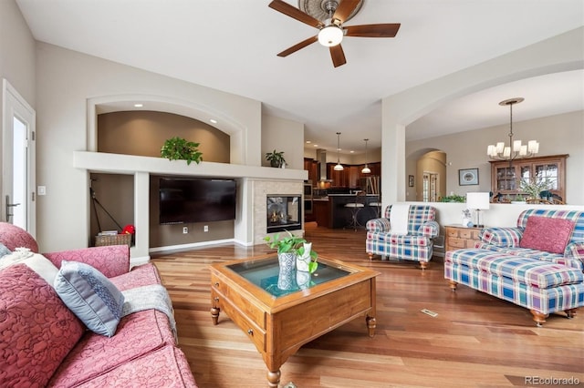 5810 Moss Ct, Golden, CO 80403 - living area featuring light wood-type flooring, ceiling fan, a chandelier, and arched walkways