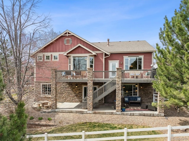 5810 Moss Ct, Golden, CO 80403 - view of front of home with stone siding, a deck, an outdoor hangout area, a patio area, and board and batten siding