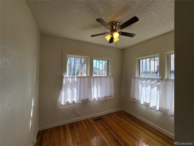 spare room with a textured ceiling, wood-type flooring, and ceiling fan