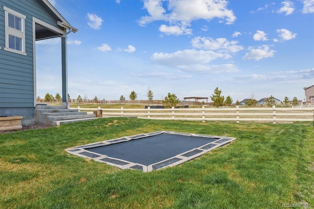 view of yard with fence and a rural view