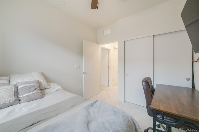 bedroom with ceiling fan, a closet, and light carpet