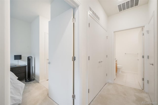 hallway featuring light colored carpet