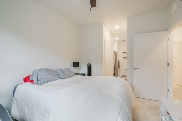 bedroom featuring ceiling fan, connected bathroom, and light colored carpet