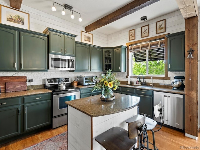 10273 Salida St, Commerce City, CO 80022 - kitchen with tasteful backsplash, appliances with stainless steel finishes, green cabinetry, and a sink
