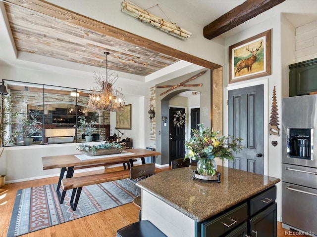 10273 Salida St, Commerce City, CO 80022 - kitchen with light wood-style flooring, arched walkways, dark stone counters, beamed ceiling, and stainless steel refrigerator with ice dispenser