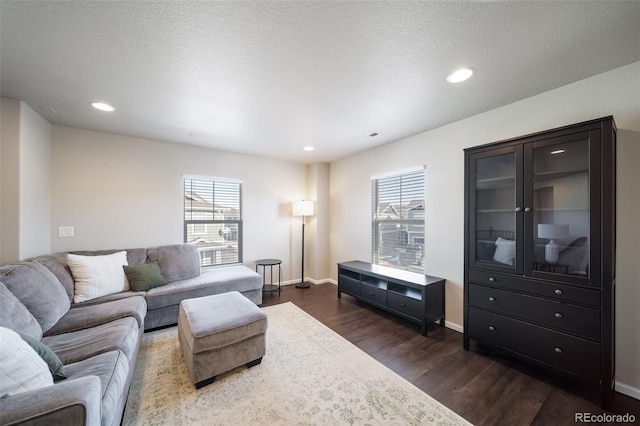 living room with dark hardwood / wood-style floors and a textured ceiling