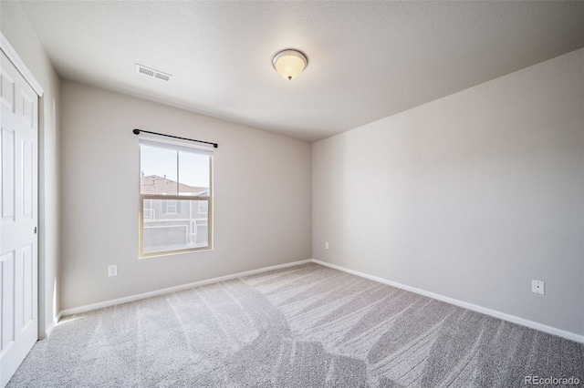 unfurnished room featuring light colored carpet