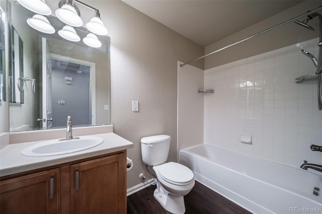 full bathroom with vanity, wood-type flooring, tiled shower / bath, and toilet