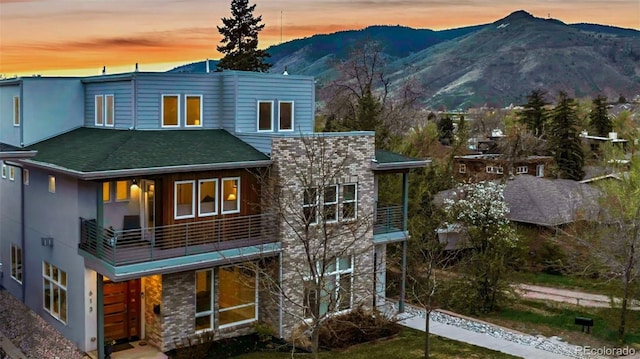 613 Iowa St, Golden, CO 80403 - view of front facade featuring stucco siding, a mountain view, a balcony, and a shingled roof