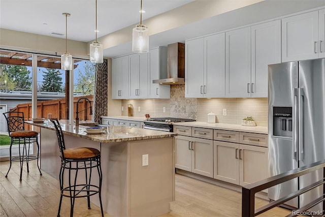 613 Iowa St, Golden, CO 80403 - kitchen with light wood finished floors, a sink, appliances with stainless steel finishes, and wall chimney range hood