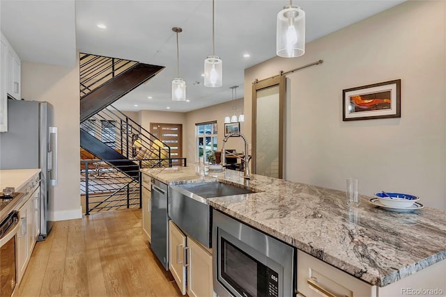 613 Iowa St, Golden, CO 80403 - kitchen featuring light wood-type flooring, stainless steel appliances, a sink, and hanging light fixtures