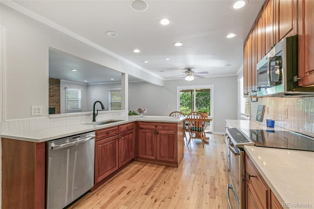 8474 E Otero Cir, Centennial, CO 80112 - kitchen featuring stainless steel appliances, a sink, light wood finished floors, light countertops, and recessed lighting