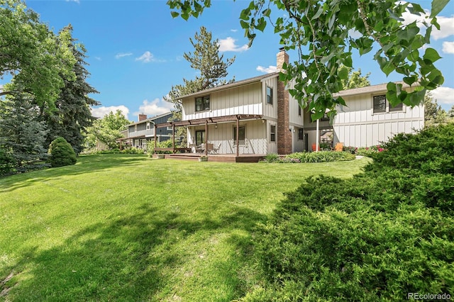 8474 E Otero Cir, Centennial, CO 80112 - back of property with a chimney, board and batten siding, a yard, and a deck