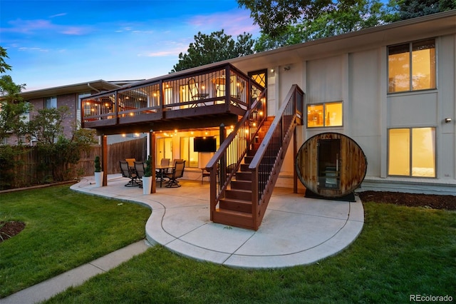 13693 W Utah Cir, Lakewood, CO 80228 - back of house at dusk with a wooden deck, a patio area, stairs, and board and batten siding