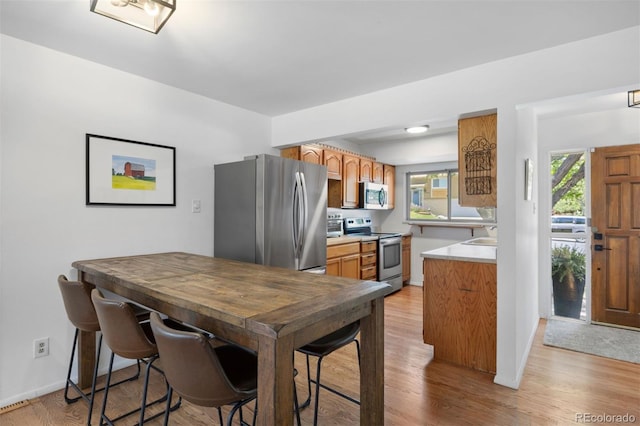 13693 W Utah Cir, Lakewood, CO 80228 - kitchen with appliances with stainless steel finishes, light wood finished floors, and light countertops