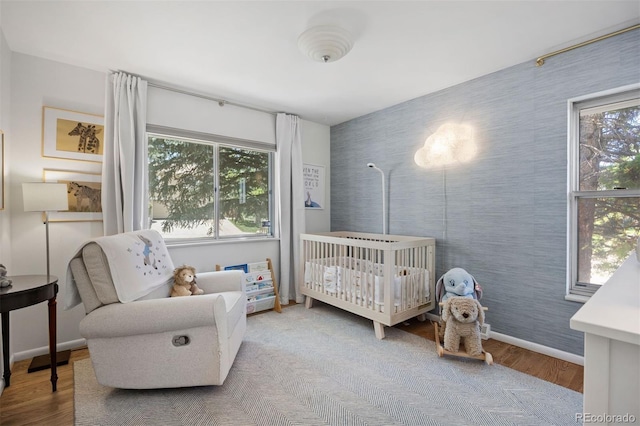 13693 W Utah Cir, Lakewood, CO 80228 - bedroom featuring wood finished floors, multiple windows, and a nursery area