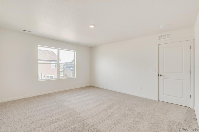 spare room featuring light colored carpet