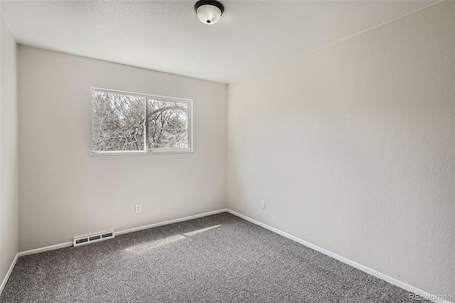 carpeted empty room featuring baseboards and visible vents
