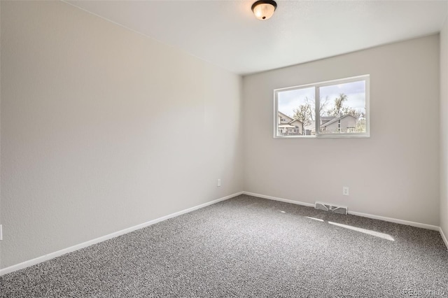 empty room with baseboards, visible vents, and carpet floors