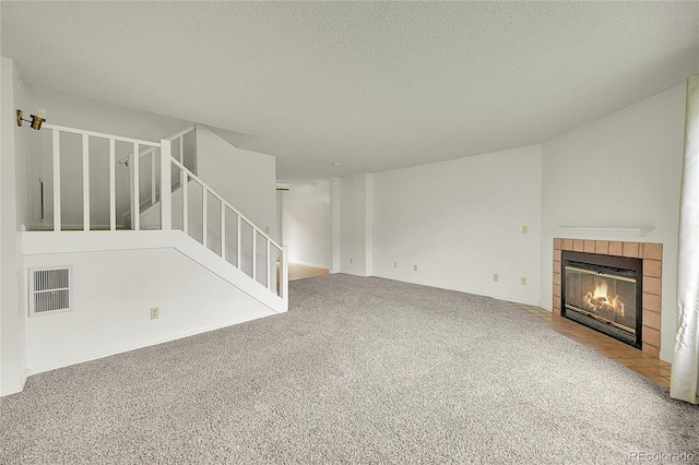 5275 Cody St, Arvada, CO 80002 - unfurnished living room with carpet, a textured ceiling, a fireplace, and stairway