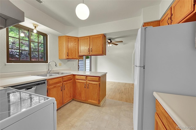 5275 Cody St, Arvada, CO 80002 - kitchen featuring white appliances, a peninsula, light countertops, brown cabinets, and a ceiling fan