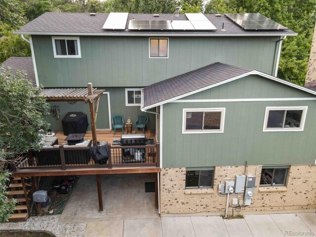 rear view of property featuring a wooden deck and a patio area