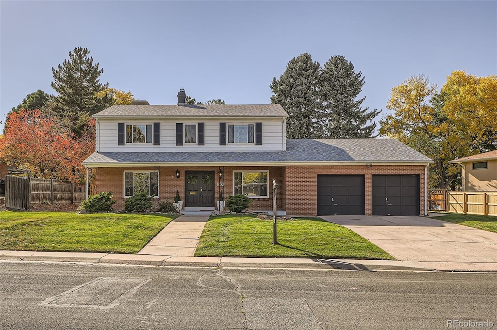 front facade with a front yard, a porch, and a garage