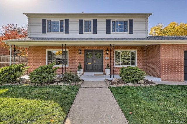 view of front property featuring covered porch and a front lawn