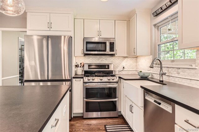 7708 S Krameria Ct, Centennial, CO 80112 - kitchen with stainless steel appliances, dark countertops, white cabinets, dark wood-style flooring, and backsplash