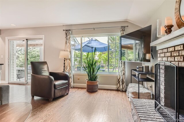 7708 S Krameria Ct, Centennial, CO 80112 - living area featuring a fireplace, wood finished floors, lofted ceiling, baseboards, and healthy amount of natural light