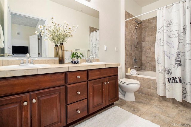 full bath featuring a sink, tiled shower / bath, toilet, and double vanity