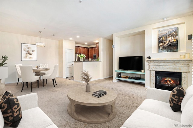 living room with recessed lighting, light colored carpet, and a glass covered fireplace