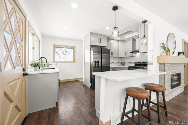 11710 Spruce Canyon Cir, Golden, CO 80403 - kitchen with stainless steel fridge with ice dispenser, range with gas stovetop, a sink, a peninsula, and tasteful backsplash
