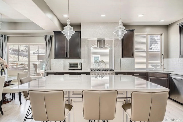 1815 Avery Way, Castle Rock, CO 80109 - kitchen with a sink, wall chimney exhaust hood, stainless steel dishwasher, tasteful backsplash, and a kitchen island