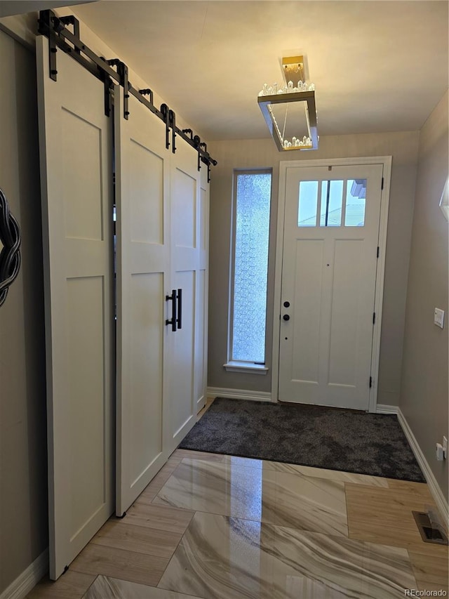 1815 Avery Way, Castle Rock, CO 80109 - entrance foyer with a barn door, baseboards, and light marble finish floors