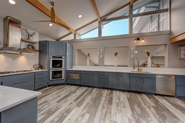 kitchen featuring ventilation hood, tasteful backsplash, beamed ceiling, sink, and stainless steel appliances