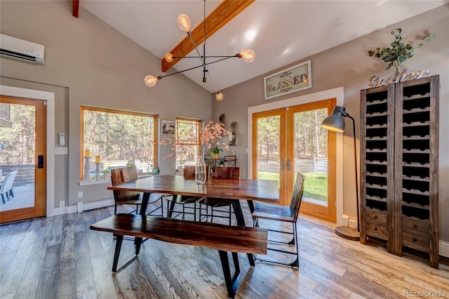 dining area featuring beamed ceiling, a wall mounted air conditioner, french doors, and a wealth of natural light