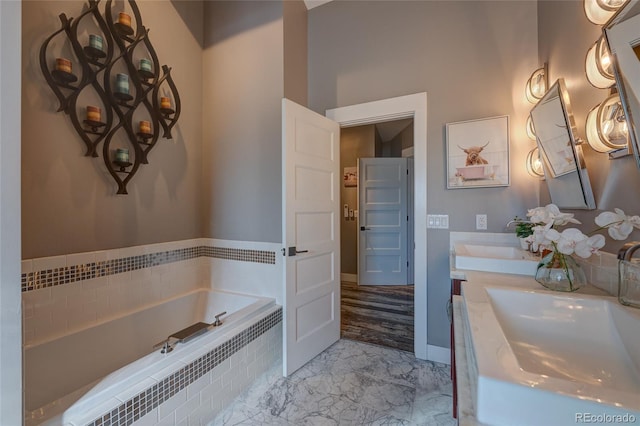 bathroom featuring vanity and tiled bath