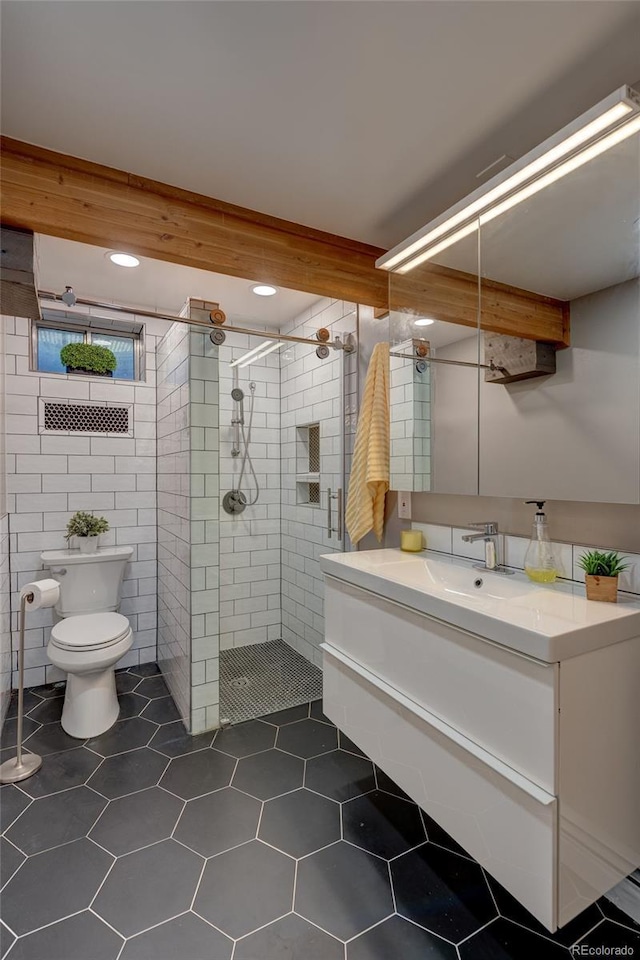 bathroom featuring beamed ceiling, tiled shower, vanity, and tile patterned flooring