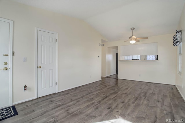 interior space with baseboards, wood finished floors, a ceiling fan, and vaulted ceiling