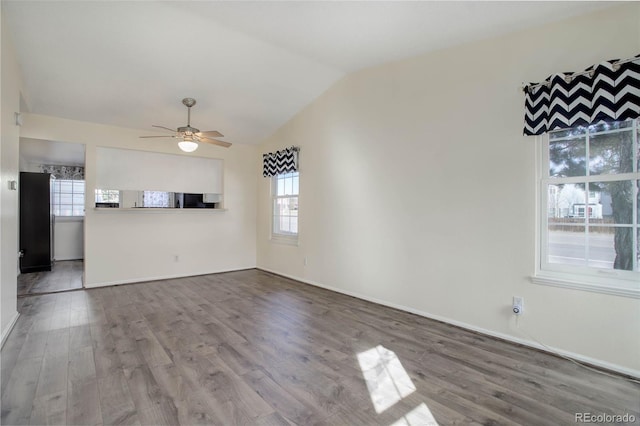 unfurnished living room featuring ceiling fan, baseboards, lofted ceiling, and wood finished floors