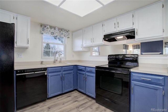 kitchen with under cabinet range hood, blue cabinetry, black appliances, and a sink