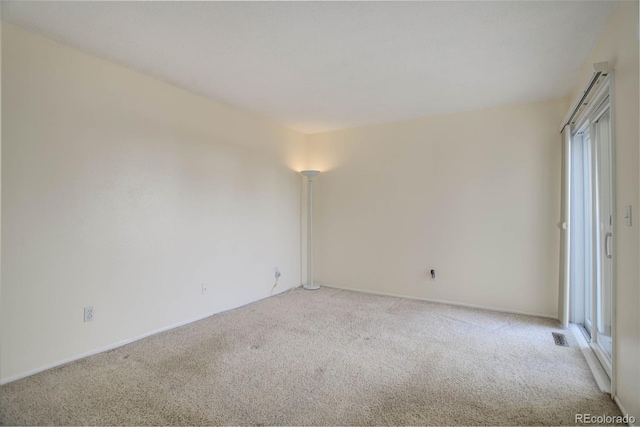 empty room featuring visible vents and light carpet