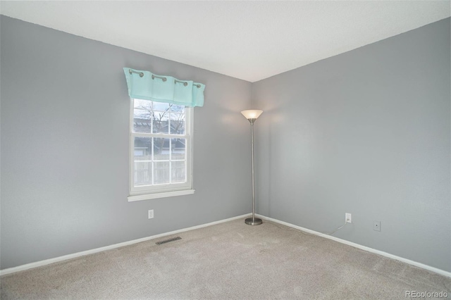 spare room with visible vents, baseboards, and carpet