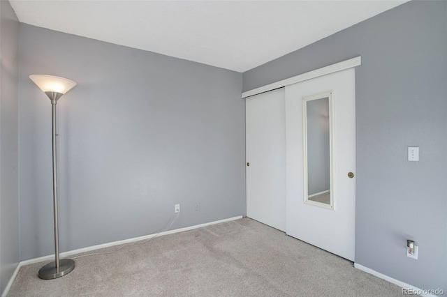 unfurnished bedroom featuring a closet, baseboards, and carpet